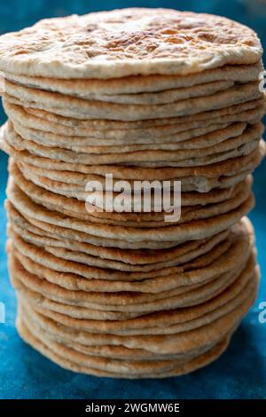 Fladenbrot Lavash, Chapati, Naan, ein Haufen Tortilla auf blauem Hintergrund hausgemachtes Fladenbrot gestapelt. Stockfoto