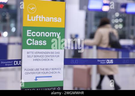 Düsseldorf, Deutschland. Februar 2024. Ein Schild mit der Aufschrift „Lufthansa Economy Class“ steht im Lufthansa Check-in-Bereich am Flughafen Düsseldorf. Lufthansa und ihre Kunden stehen vor der nächsten Streikwelle mit zahlreichen Flugannullierungen und -Verspätungen. Am Mittwoch (7. Februar) hat die gewerkschaft Verdi Bodenpersonal mehrerer Lufthansa-Unternehmen, darunter auch technisches Personal, zu einem ganztägigen Warnstreik aufgerufen. Quelle: David Young/dpa/Alamy Live News Stockfoto