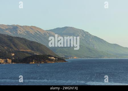 Blick auf ferne Hügel und Berge über dem See Ohrid in Nordmakedonien, aufgenommen zur goldenen Stunde nahe Sonnenuntergang an einem schönen Sommertag mit einem ruhigen See. Stockfoto