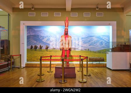 Eine Ausstellung einer typischen alten Kriegeruniform, rot-goldenem Muster, Stil. Im Archäologischen Museum in Almaty, Kasachstan. Stockfoto