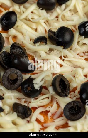 Pizzateig mit Käse und Fleisch und Oliven, hausgemachte Pizza aus Weizenteig mit Tomatenpaste mit Gewürzen Käse Fleisch und Oliven Stockfoto