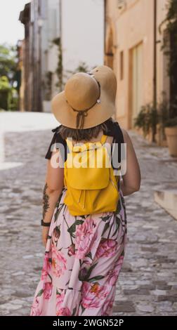 In Bewunderung verloren: Eine Frau wandert durch die engen Steinstraßen von Santarcangelo di Romagna, fasziniert von der zeitlosen Schönheit seiner Architektur. Stockfoto