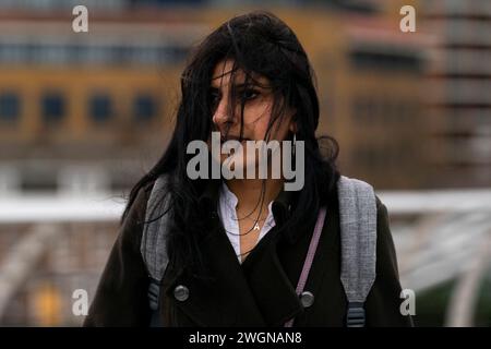 Menschen trotzen dem Wetter, wenn sie die Millennium Bridge in London überqueren. Ein starkes Schneeband könnte später in dieser Woche zu Störungen führen, wobei in höheren Gebieten bis zu 20 cm möglich sind. Bilddatum: Dienstag, 6. Februar 2024. Stockfoto