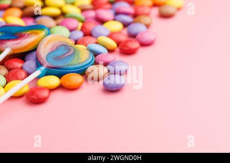Bunte süße Bonbons und Lutscher. Süße Süßigkeiten auf rosa Hintergrund. Stockfoto