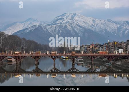 Pendler spazieren an einem kalten Winterabend in Srinagar entlang der hölzernen Fußbrücke. Das Wetter im Kaschmir-Tal hat sich verbessert, nachdem es nach längerem Trockentewetter erneut Schneefall bekommen hat. Der Flugbetrieb am Flughafen Srinagar und der Straßenverkehr auf der Autobahn Srinagar-Jammu, die am Sonntag vom Schneefall betroffen waren, wurden am Montag wiederhergestellt. (Foto: Saqib Majeed / SOPA Images/SIPA USA) Stockfoto