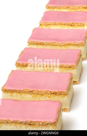 Frisch gebackenes holländisches Tompouce-Gebäck in einer Reihe auf weißem Hintergrund Nahaufnahme Stockfoto