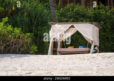 Weiße Stranddächer bei Sonnenuntergang. Luxuriöse Strandzelte im luxuriösen Strandresort. Sommer-Strandkonzept, unbeschwert, Erholung am Meer, Niemand am Strand.Garten Stockfoto