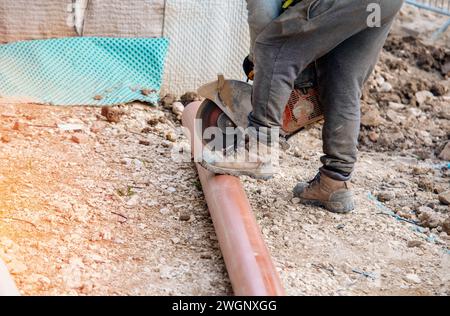 Verlegung von Kunststoffabflussrohren in den Boden als Teil eines neuen Entwässerungssystems bei Wohnprojekten Stockfoto