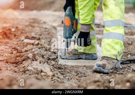 Bauarbeiter bohren durch Hartbeton mit einem Akku-Bohrer Stockfoto