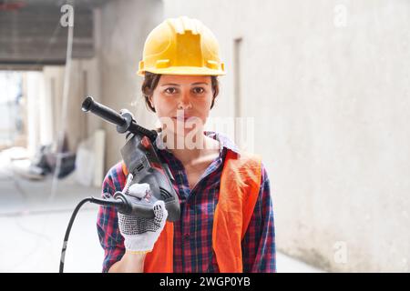 Selbstbewusste Bauarbeiterin, die Arbeitskleidung trägt Stockfoto