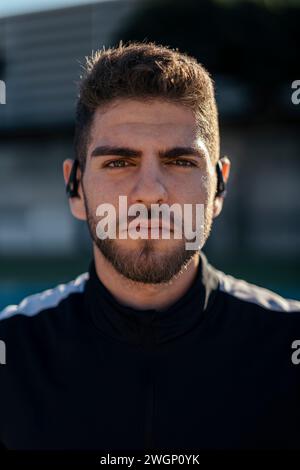 Eine Nahaufnahme eines Mannes, der ein schwarzes Hemd und Ohrstöpsel trägt Stockfoto