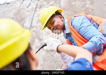 Verschiedene Maurer halten Eimer zusammen Stockfoto