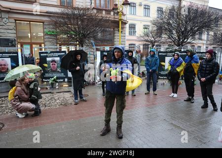 IWANO-FRANKIWSK, UKRAINE - 05. FEBRUAR 2024 - Ein Freiwilliger, Blogger und ehemaliger Asow-Regimentssoldat Petro Skrypka, der von Kiew nach Iwano-Frankiwsk ging, um Geld für die ukrainischen Streitkräfte zu sammeln, erschießt ein weiches Spielzeug, das ihm von einer Frau, Iwano-Frankowsk, Westukraine, präsentiert wurde. Stockfoto