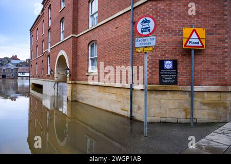 River Ouse platzte Ufer nach starkem Regen (Flussufer untergetaucht, hohe Höhe, Gebäude überflutet, Hochwasserbarriere geschlossen) - York, North Yorkshire, England, Großbritannien. Stockfoto