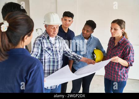 Verschiedene Kollegen und Architekten treffen sich im Rahmen von Blueprint Stockfoto