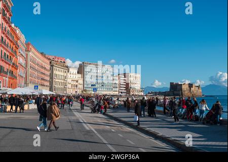 Neapel, Italien - 18. Dezember 2022: Eine geschäftige Menschenmenge von Touristen und Einwohnern, die in stilvoller Outdoor-Kleidung gekleidet sind, erwacht beim caracciolo-Promen Stockfoto