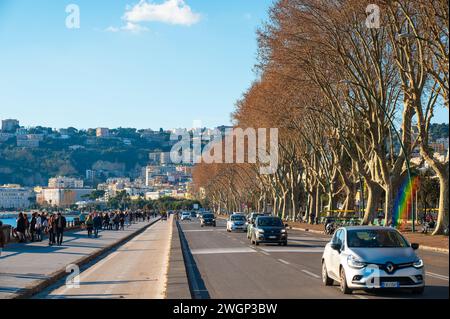 Neapel, Italien - 18. Dezember 2022: Eine belebte Straße in Neapel, Italien, voller lebendiger Menschen und Autos, die entlang des malerischen Caracciolo fahren Stockfoto