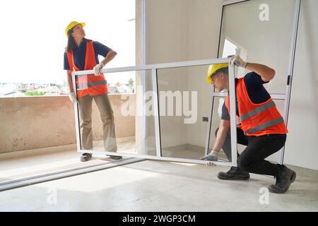 Zimmerleute installieren Fensterrahmen im Haus Stockfoto