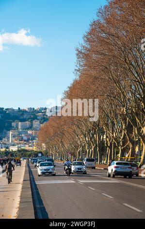 Neapel, Italien - 18. Dezember 2022: Eine belebte Straße in Neapel, Italien, voller lebendiger Menschen und Autos, die entlang des malerischen Caracciolo fahren Stockfoto