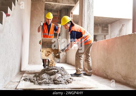 Junge männliche und weibliche Maurer arbeiten zusammen Stockfoto