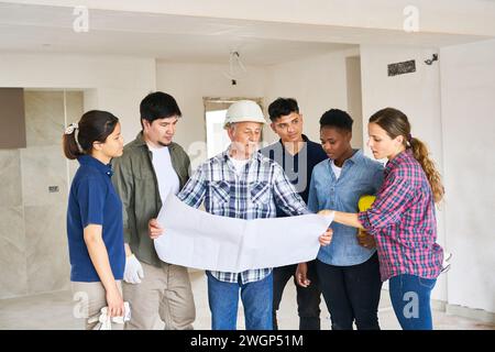 Verschiedene Kollegen und Architekten treffen sich im Rahmen von Blueprint Stockfoto