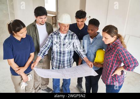 Treffen des Auftragnehmers über einen Plan mit Kollegen Stockfoto