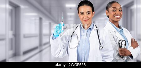 Zwei Frauen im Gesundheitswesen in einer klinischen Umgebung, eine mit einer Spritze Stockfoto