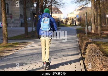 Mann fahrt auf E-Scooter, E-Roller in der Stadt von München, Radweg Stadtverkehr, urbane Mobilität *** man fährt mit E-Scooter, E-Roller in der Stadt München, Radweg Stadtverkehr, urbane Mobilität Stockfoto