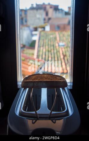 Toaster auf der Fensterbank eines Landhauses. Frisch zubereitete Scheibe über dem Rack Stockfoto