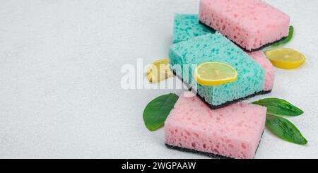 Verschiedene Schwämme zum Waschen von Geschirr. Bio-Reinigungskonzept, Zitronenfrische. Steinbetonhintergrund, flach, Bannerformat Stockfoto