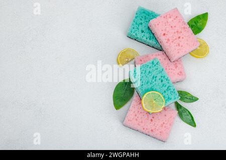 Verschiedene Schwämme zum Waschen von Geschirr. Bio-Reinigungskonzept, Zitronenfrische. Steinbetonhintergrund, flache Lage, Draufsicht Stockfoto