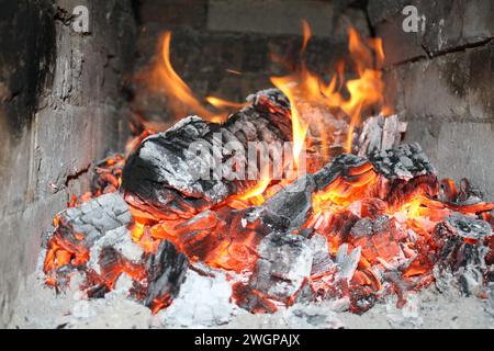 Helles Feuer brennendes Eichenholz in einem rustikalen Steinofen, Nahaufnahme Stockfoto