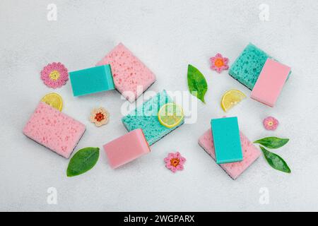 Verschiedene Schwämme zum Waschen von Geschirr. Bio-Reinigungskonzept, Zitronenfrische. Steinbetonhintergrund, flache Lage, Draufsicht Stockfoto