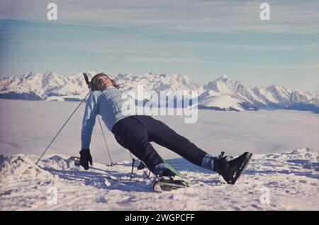 Skifahrer GER, 20240101, Aufnahme ca. 1966, Skifahrer in den Alpen, Mann sonnt sich auf einer Konstruktion aus Skistöcken und Ski, auf einer Bergkuppe über dem Nebel im Tal *** Skier GER, 20240101,Foto ca 1966, Skier in den Alpen, Mann sonnt sich auf einer Konstruktion aus Skistöcken und Skiern, auf einem Berggipfel über dem Nebel im Tal Stockfoto