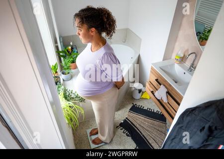 afroamerikanische schwangere Frau wiegt sich im Badezimmer Stockfoto