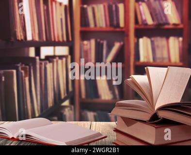 Verschiedene Bücher auf Holztisch in der Bibliothek Stockfoto