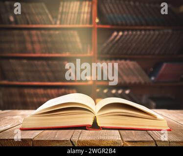 Buch auf Holztisch in Bibliothek öffnen Stockfoto