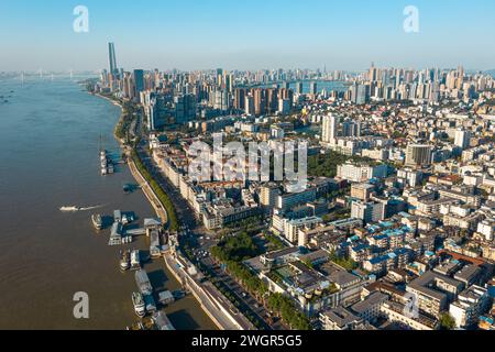 Aus der Vogelperspektive sehen Sie eine lebhafte, geschäftige Skyline der Stadt in der Nähe eines Gewässers, mit Booten unterschiedlicher Größe, die in Wuhan, China, an der Oberfläche schwimmen Stockfoto