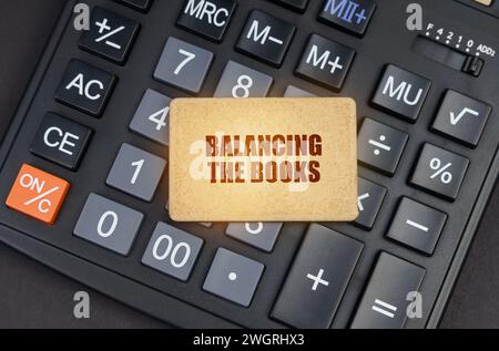 Finanzkonzept. Auf dem Rechner steht ein Schild mit der Aufschrift "Balancing the Books" Stockfoto