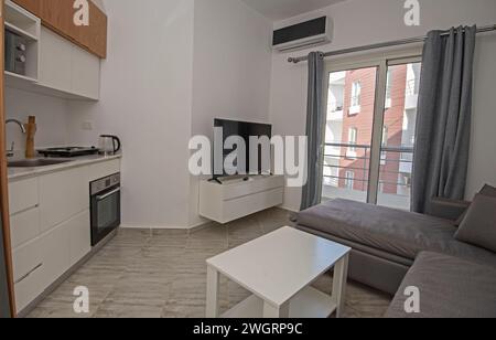 Wohnzimmer Lounge-Bereich im luxuriösen Apartment Show Home zeigt Inneneinrichtung Einrichtung mit offener Küche und Balkon Stockfoto