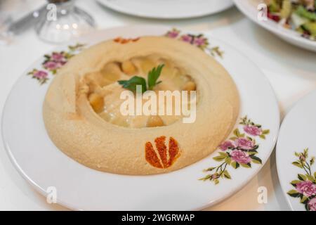 Hummus-Platte, libanesische Platte Hummus, pürierte Kichererbsen mit Zitrone, Gewürzen und Kräutern. Hausgemachter Hummus auf einem Teller. Draufsicht Stockfoto