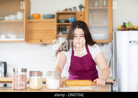 Eine junge Frau, die eine Pizza in der Küche macht Stockfoto