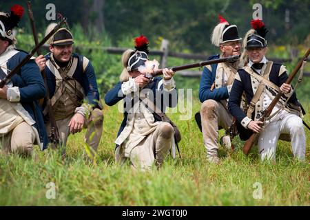 Historische Reenactors führen im Old Sturbridge Village in Sturbridge, M, eine revolutionäre Schlacht zwischen den britischen Roten Mänteln und amerikanischen Rebellen aus Stockfoto