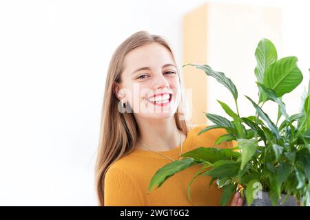 Junge Frau in einem Zimmer mit grünen Pflanzen Stockfoto