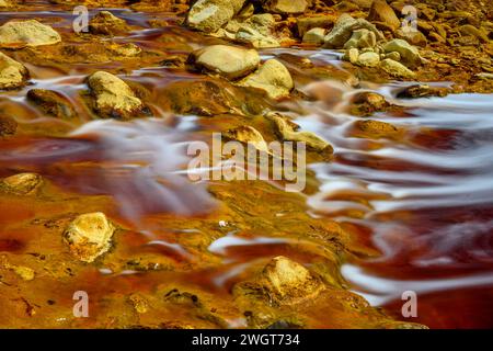 Schäumendes Wasser rauscht über die bunten, eisenbeladenen Felsen im Rio Tinto Stockfoto