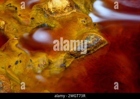 Schäumendes Wasser rauscht über die bunten, eisenbeladenen Felsen im Rio Tinto Stockfoto