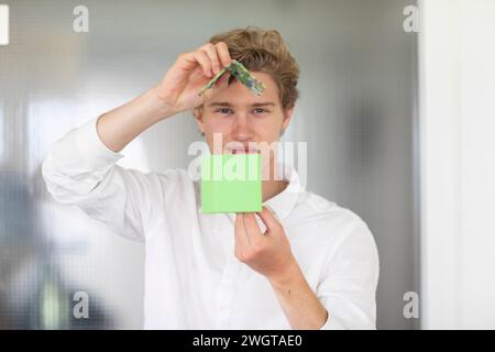 Junger Mann, der ein Modell für ein Haus mit grüner Energie baut Stockfoto