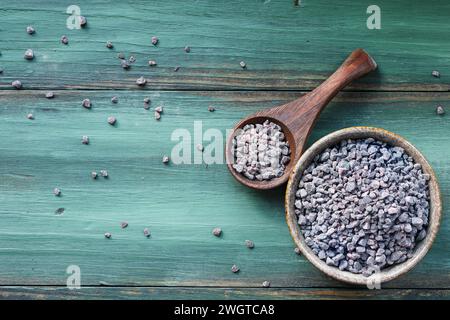 Von oben sehen Sie eine Schüssel mit Himalaya Black Salt oder Kala Namak, mit einem Holzlöffel. Flache Ansicht der Tischplatte. Stockfoto