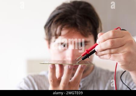 Junger Mann, der mit einem Gerät ein Werkzeug testet Stockfoto