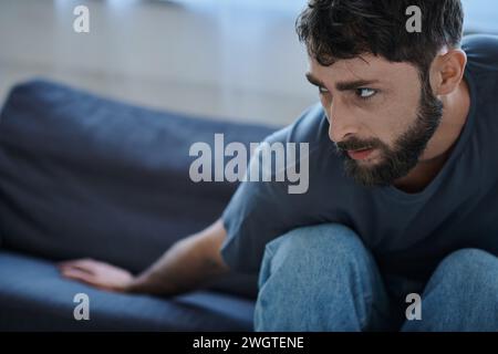 Ängstlicher Mann im täglichen T-Shirt leidet während depressiver Episode, geistiges Gesundheitsbewusstsein Stockfoto